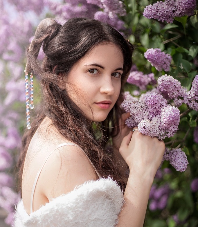 brunette young teenager girl smelling lilac