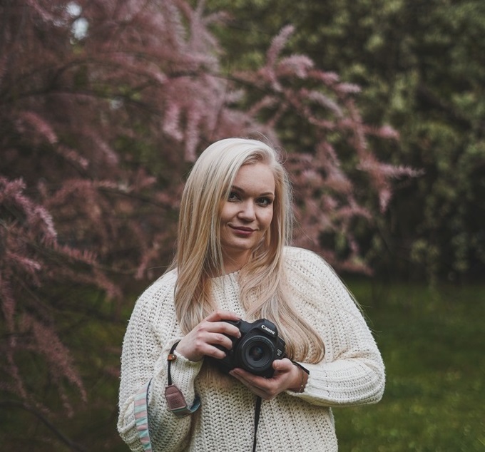 pretty girl in park and blossoms with camera in her hands