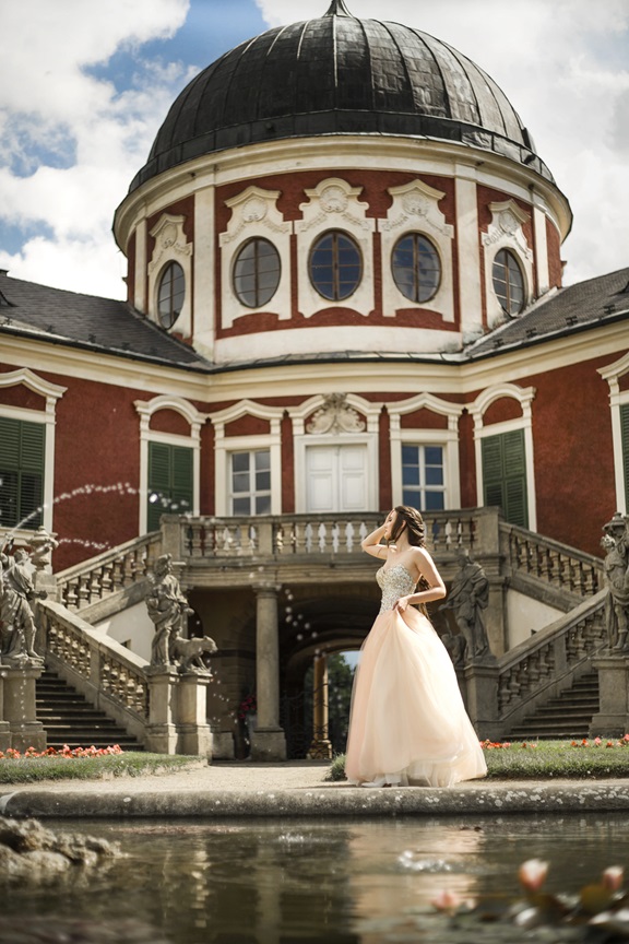 princess in long dress standing in front of Velvary castle