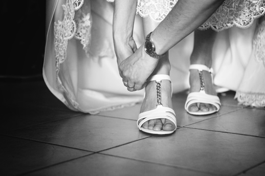 feet in high heels and white wedding dress around